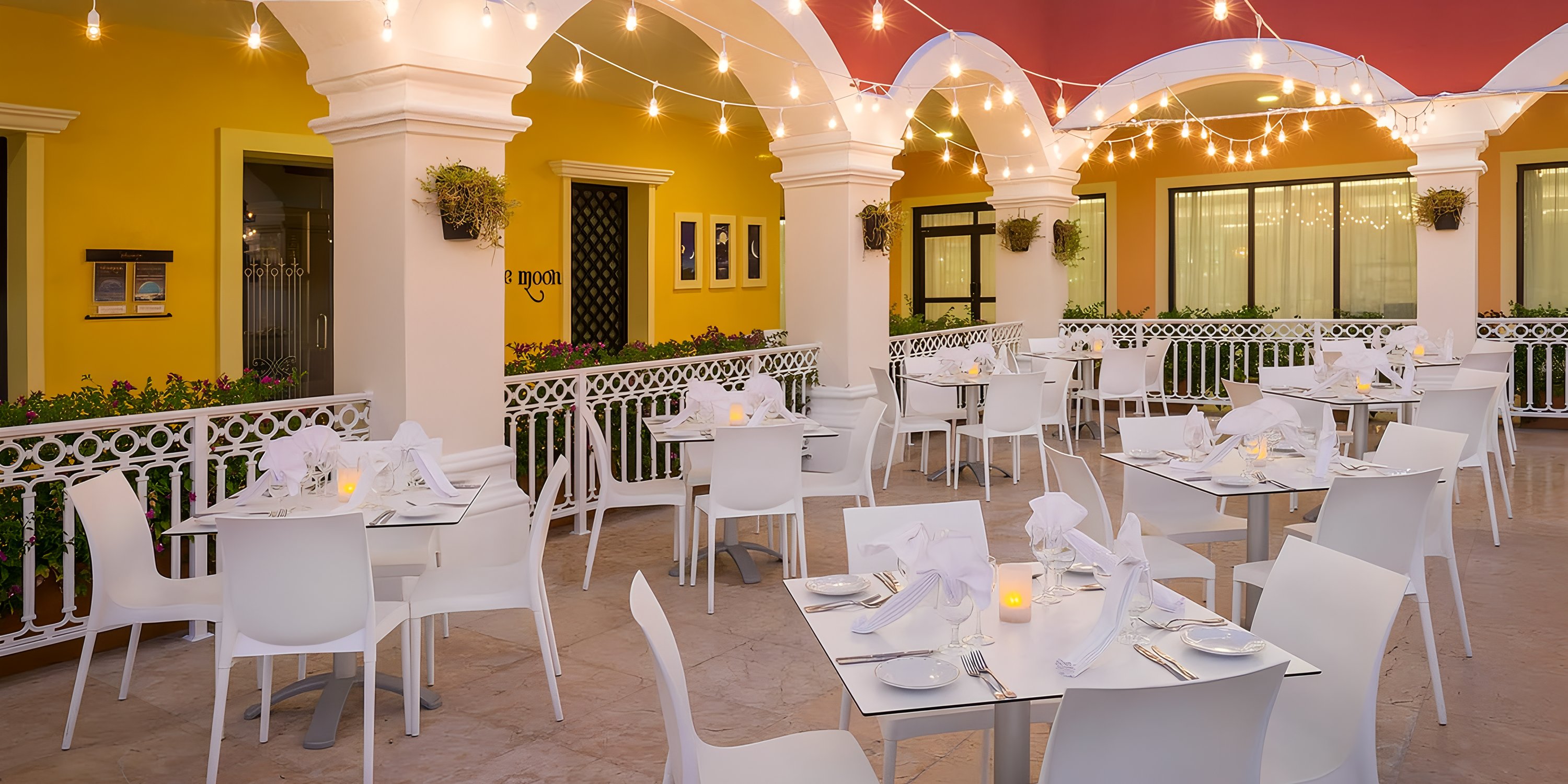 Patio at Ocean Coral and Turquesa, perfect for a destination wedding, with white tables and string lights.