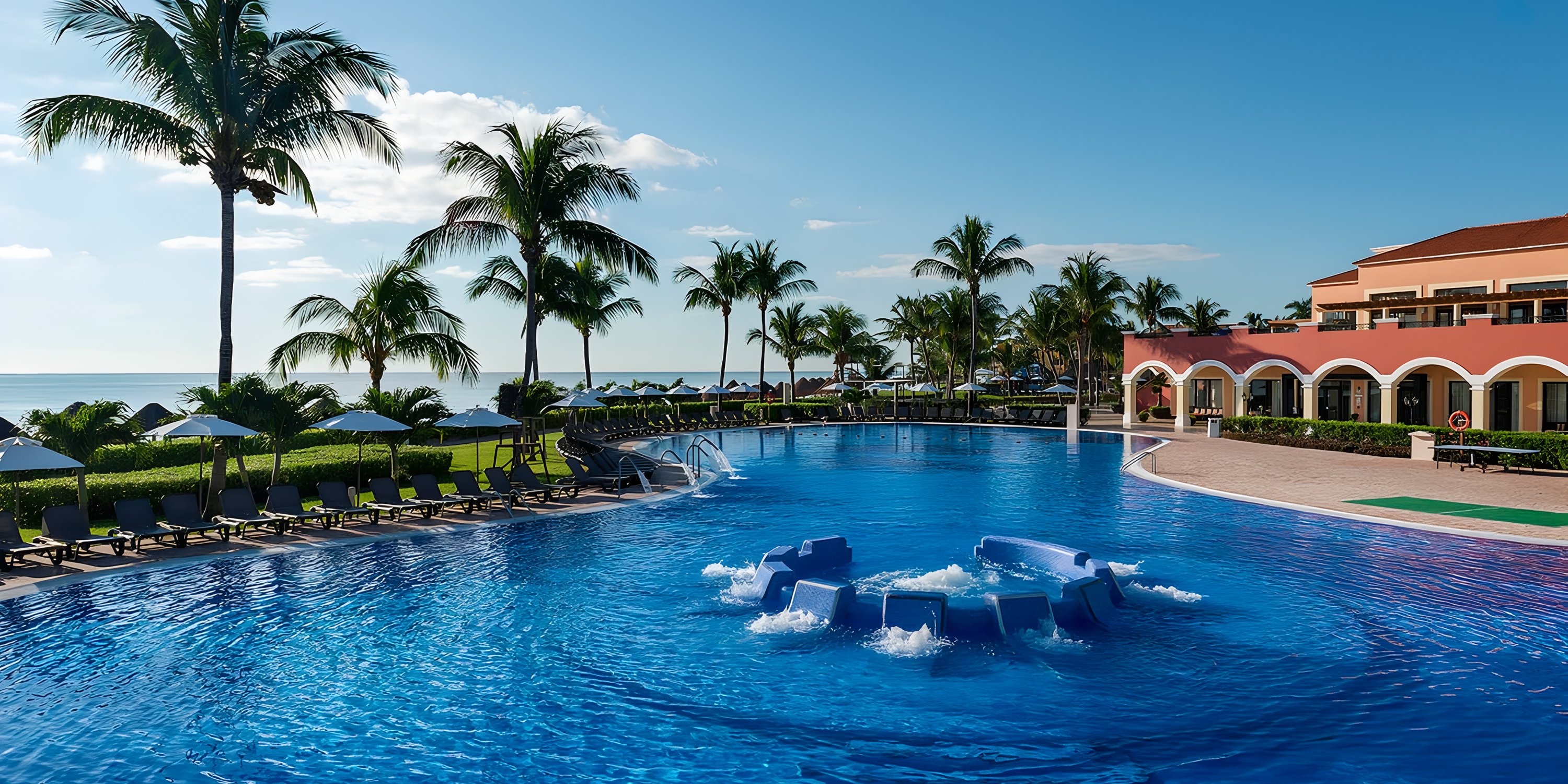 Ocean Coral and Turquesa: ideal destination wedding spot with pool, lounge chairs, palms, and ocean view.
