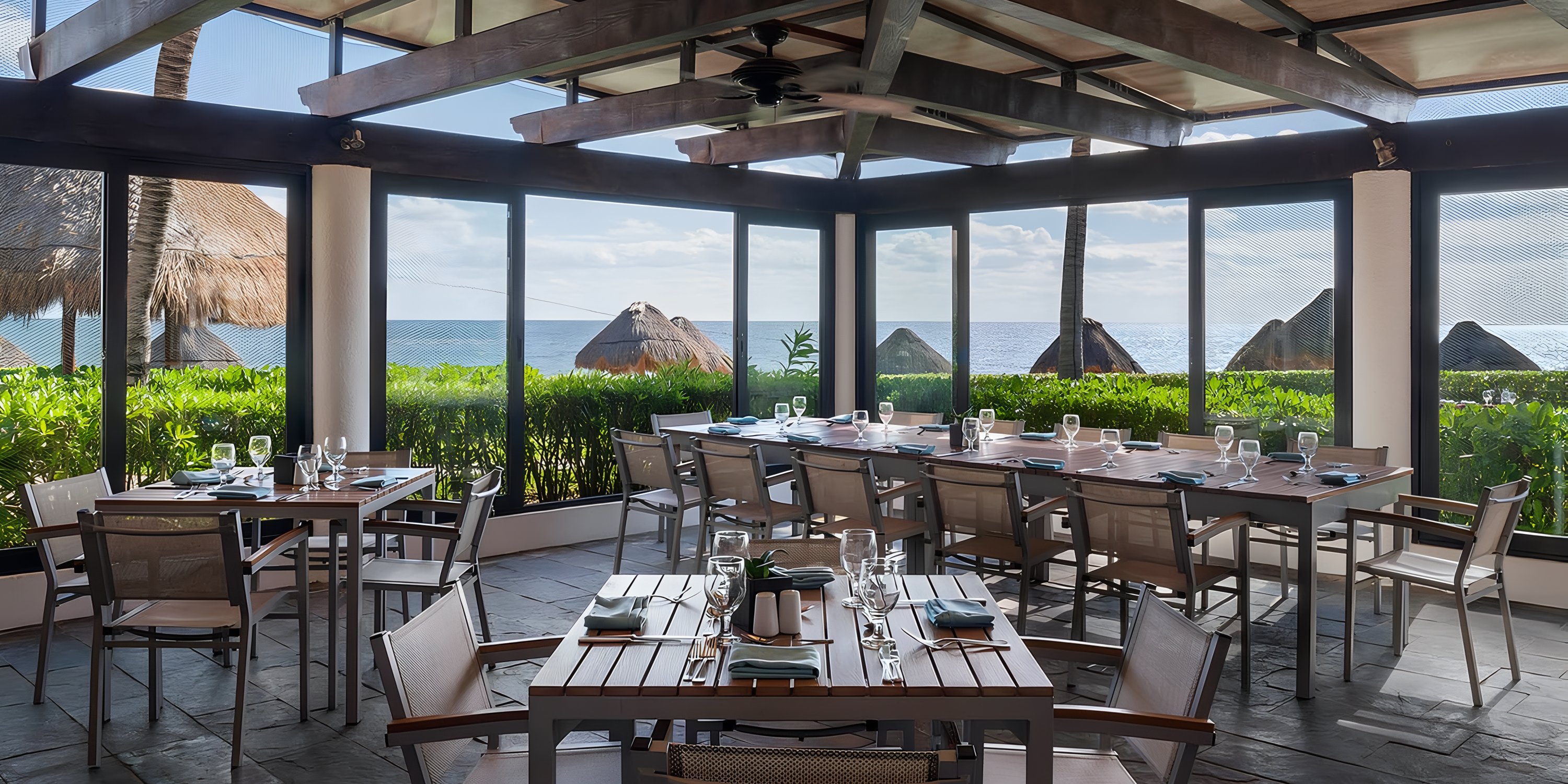Modern dining at Ocean Coral and Turquesa, perfect for destination weddings, with ocean views and thatched huts.