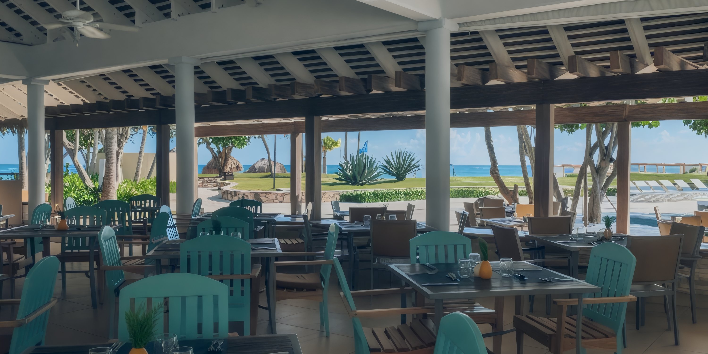 Open-air restaurant with empty tables, perfect for a destination wedding, overlooking pool and ocean.