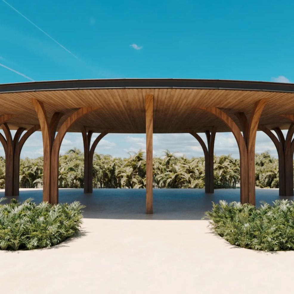 Open wooden pavilion with curved columns on sand, perfect for a destination wedding amid tropical plants.