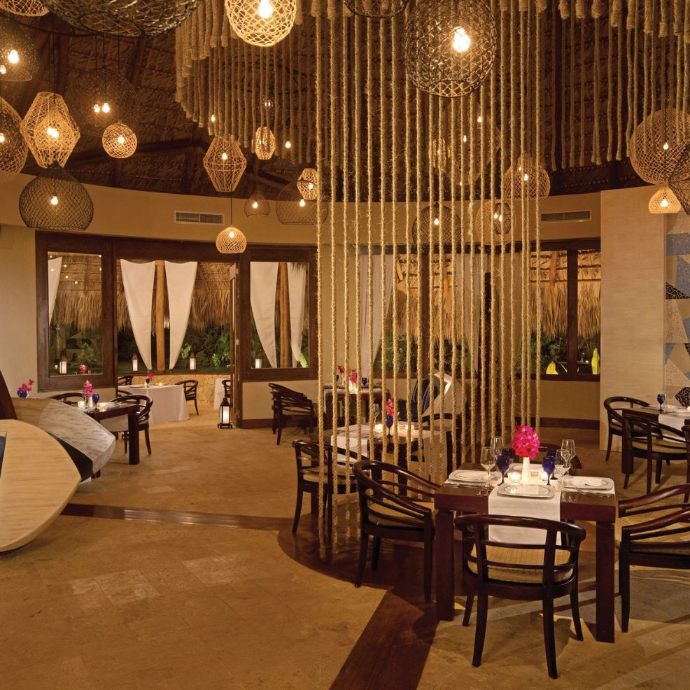 Elegant restaurant interior, ideal for a destination wedding, with rope dividers and warm lighting.