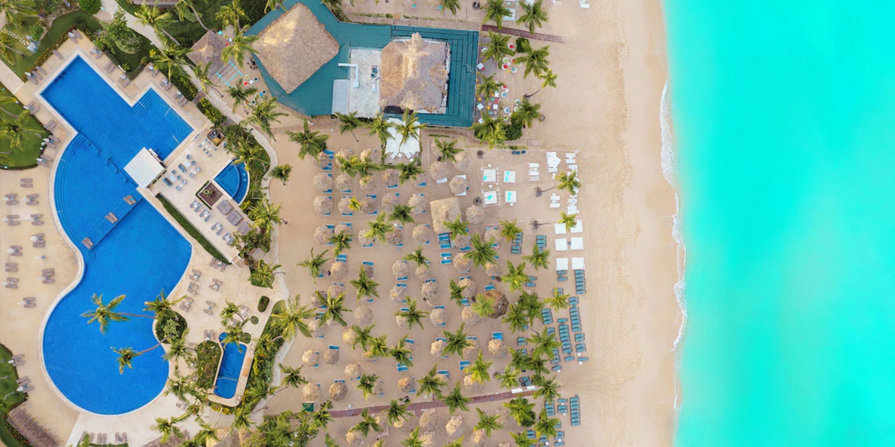 Aerial view of Catalonia Bayahibe resort, a stunning destination wedding spot with pools and turquoise water.