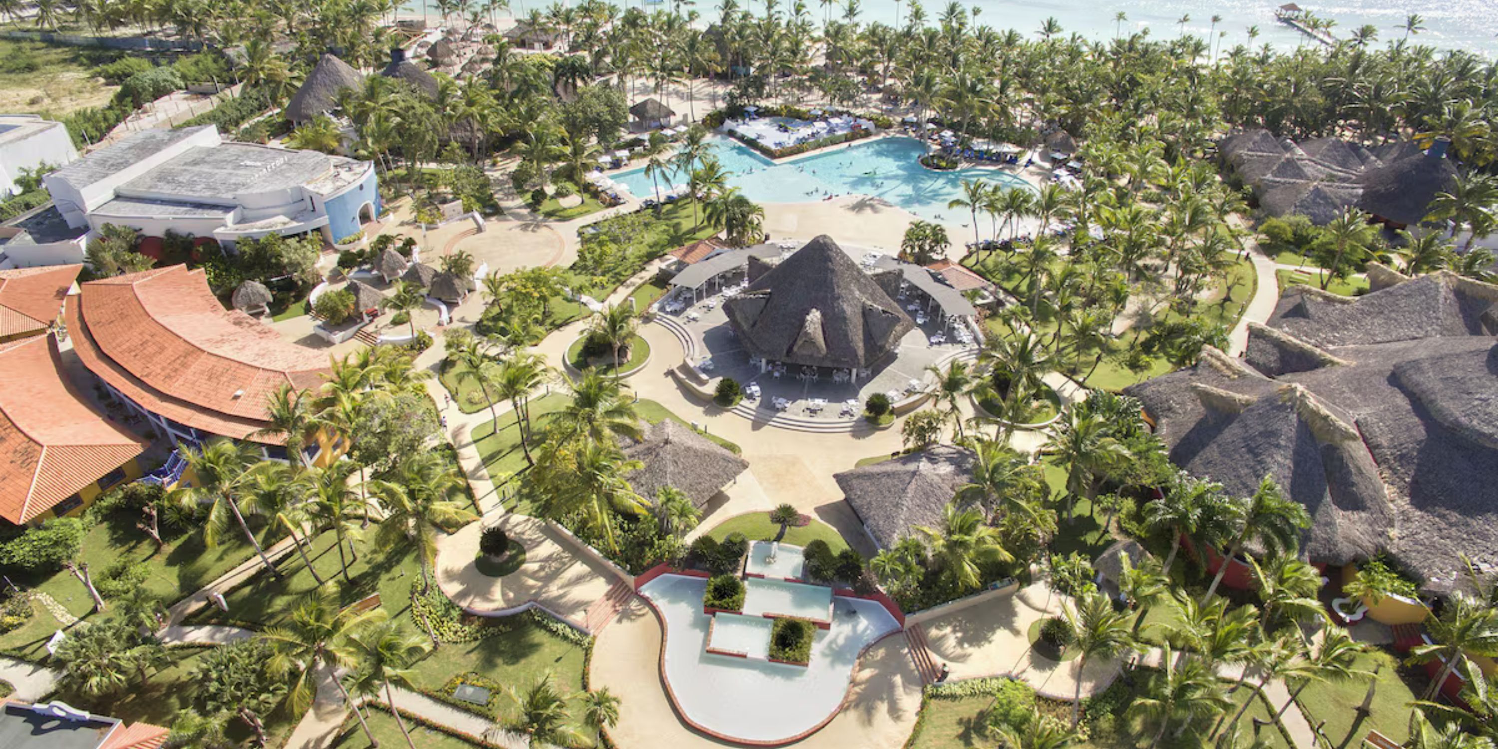 Aerial view of Catalonia Bayahibe, a popular destination wedding spot with pools, palms, and beach huts.