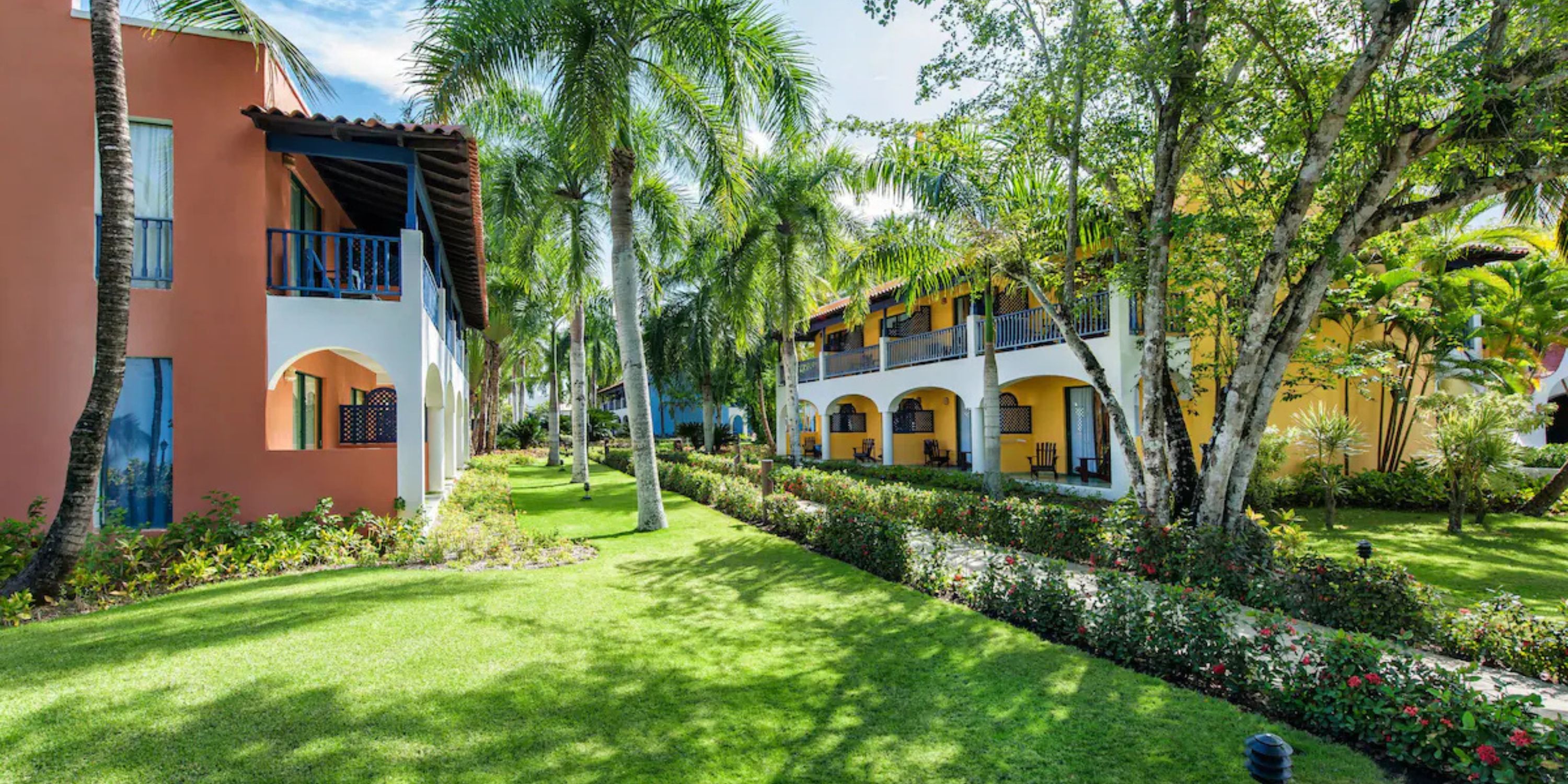Catalonia Bayahibe: Vibrant resort, perfect for a destination wedding, with balconies, palms, and lawns.