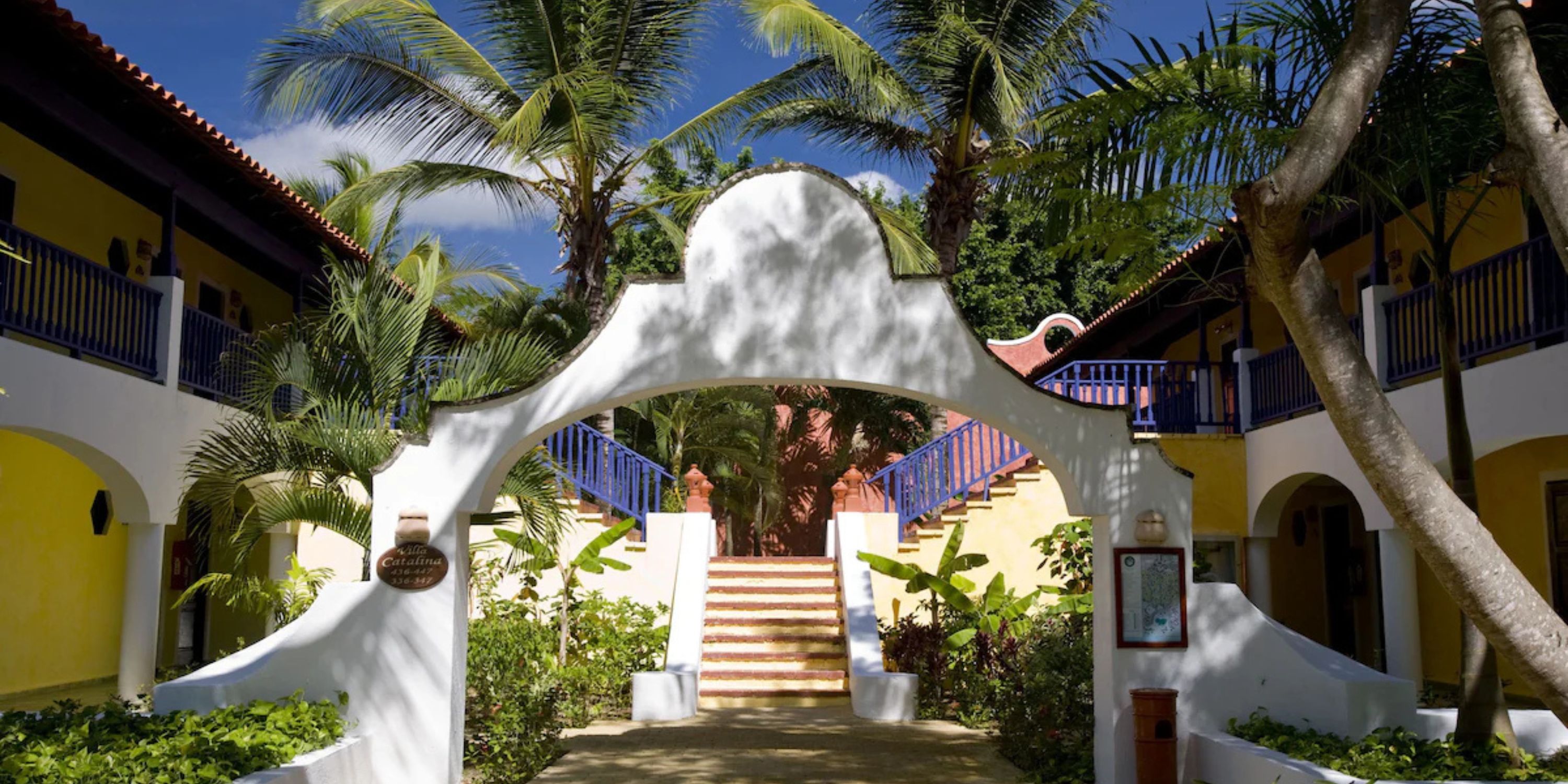 White arched entrance at Catalonia Bayahibe, perfect for a destination wedding, leads to outdoor stairs.