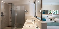 Modern bathroom at Catalonia Bayahibe, ideal for destination wedding stays, with double sinks and glass shower.