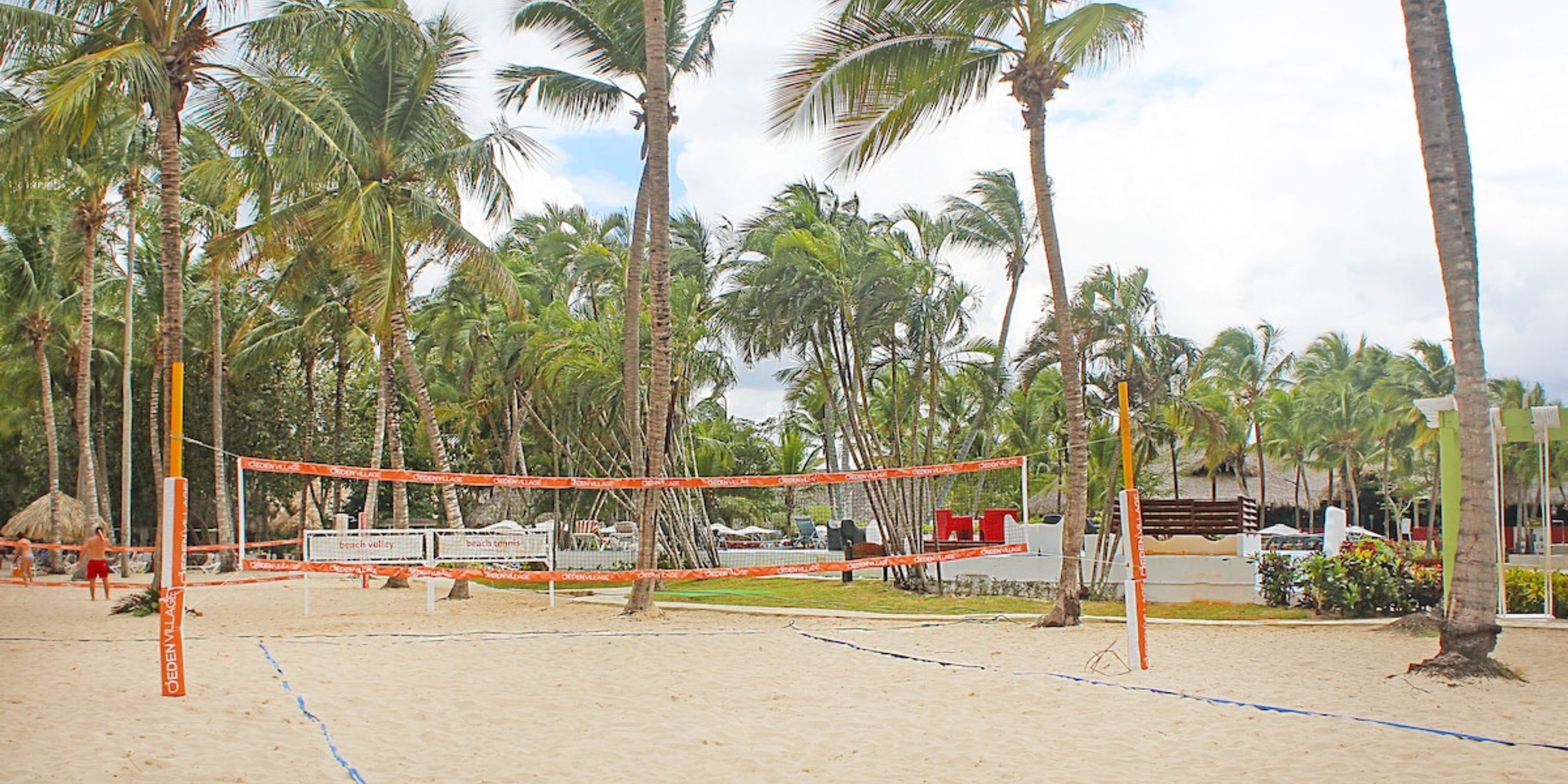 Catalonia Bayahibe: Sandy beach volleyball court by palm trees, perfect for a destination wedding setting.