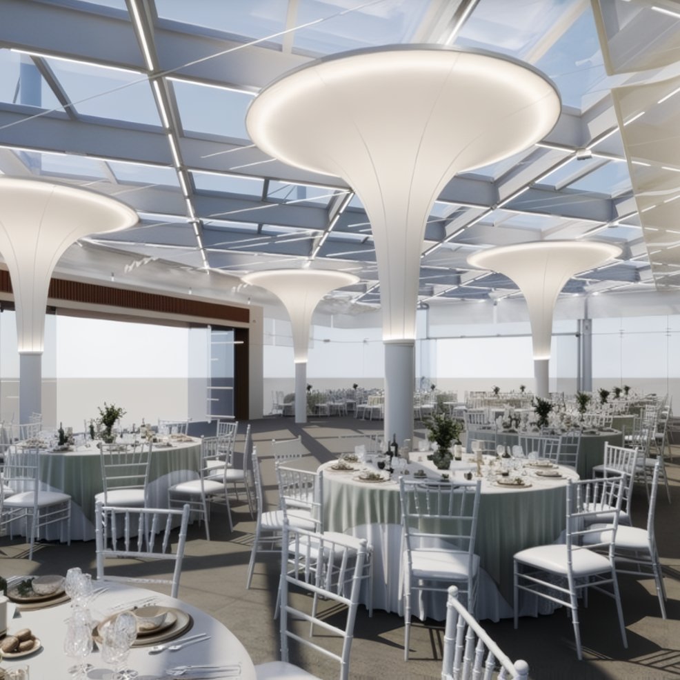 Modern banquet hall set for a destination wedding, with round tables, white chairs, and column lights.