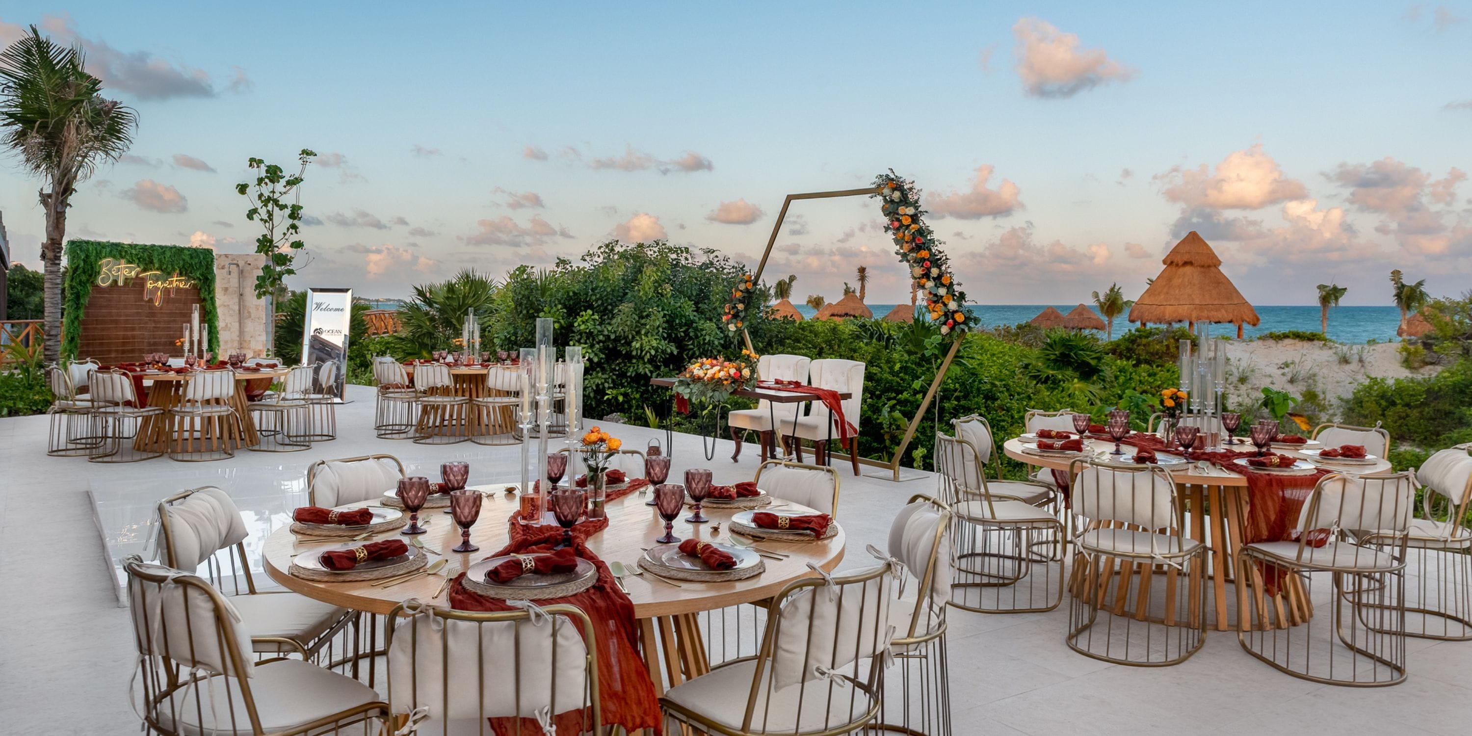 Outdoor destination wedding at Ocean Allure Costa Mujeres with elegant tables, chairs, and ocean backdrop.