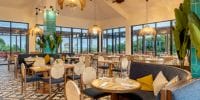 Ocean Allure Costa Mujeres set for a destination wedding, with round tables, cushioned chairs, large windows.