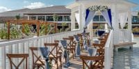 Ocean Allure Costa Mujeres: destination wedding setup with white gazebo, chairs, and blue accents over water.