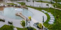 Ocean Allure Costa Mujeres showcases a dreamy wedding canopy over water with tables and chairs on green lawns.