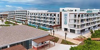 Ocean Coral and Turquesa: modern beachfront hotel, ideal for destination weddings, with balconies, pools, and palm trees.