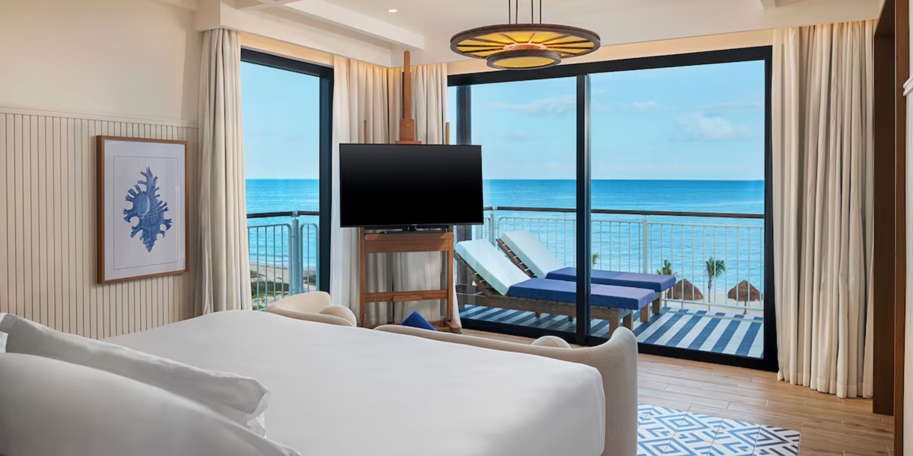 Modern room at Ocean Coral and Turquesa, perfect for a destination wedding, with bed, TV, balcony, ocean view.