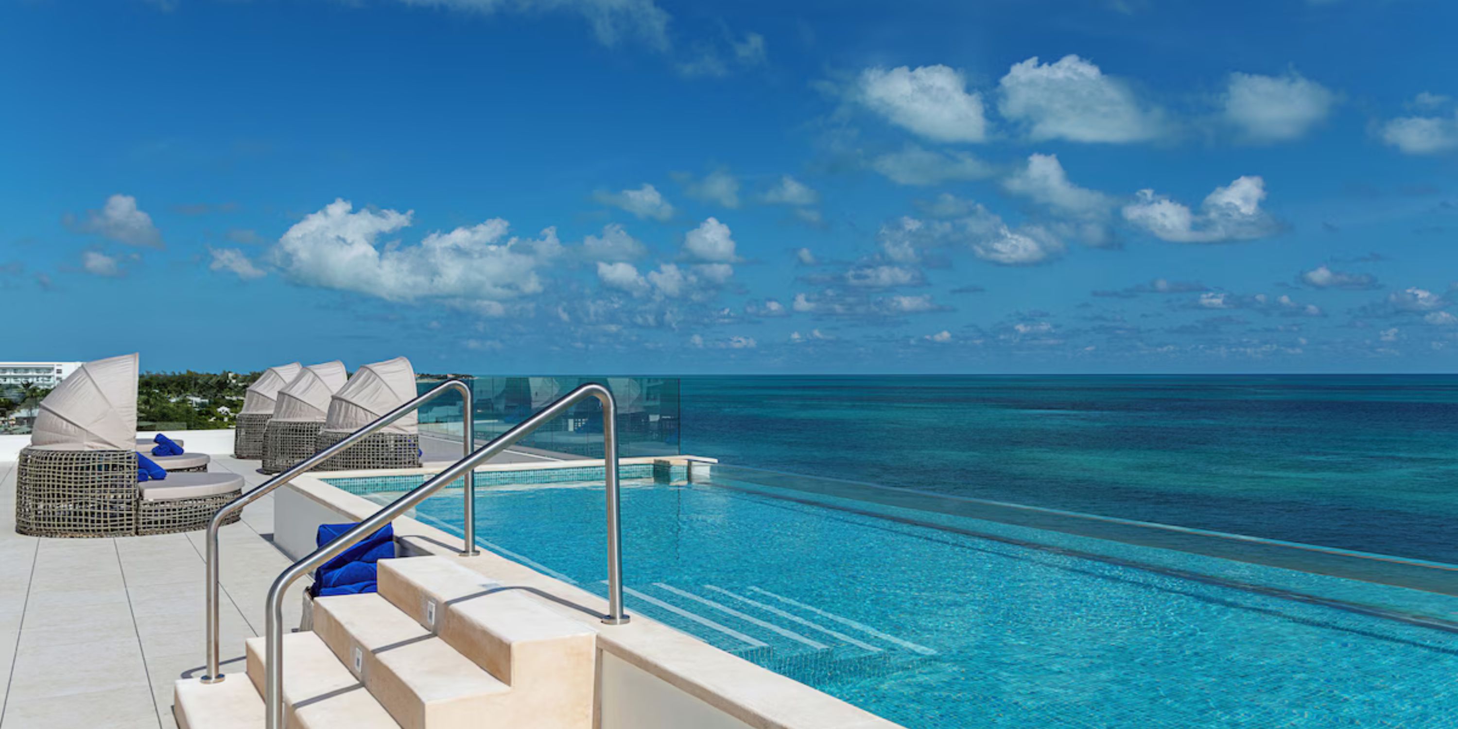 Infinity pool at Ocean Coral and Turquesa, ideal for a destination wedding with ocean views and lounge chairs.