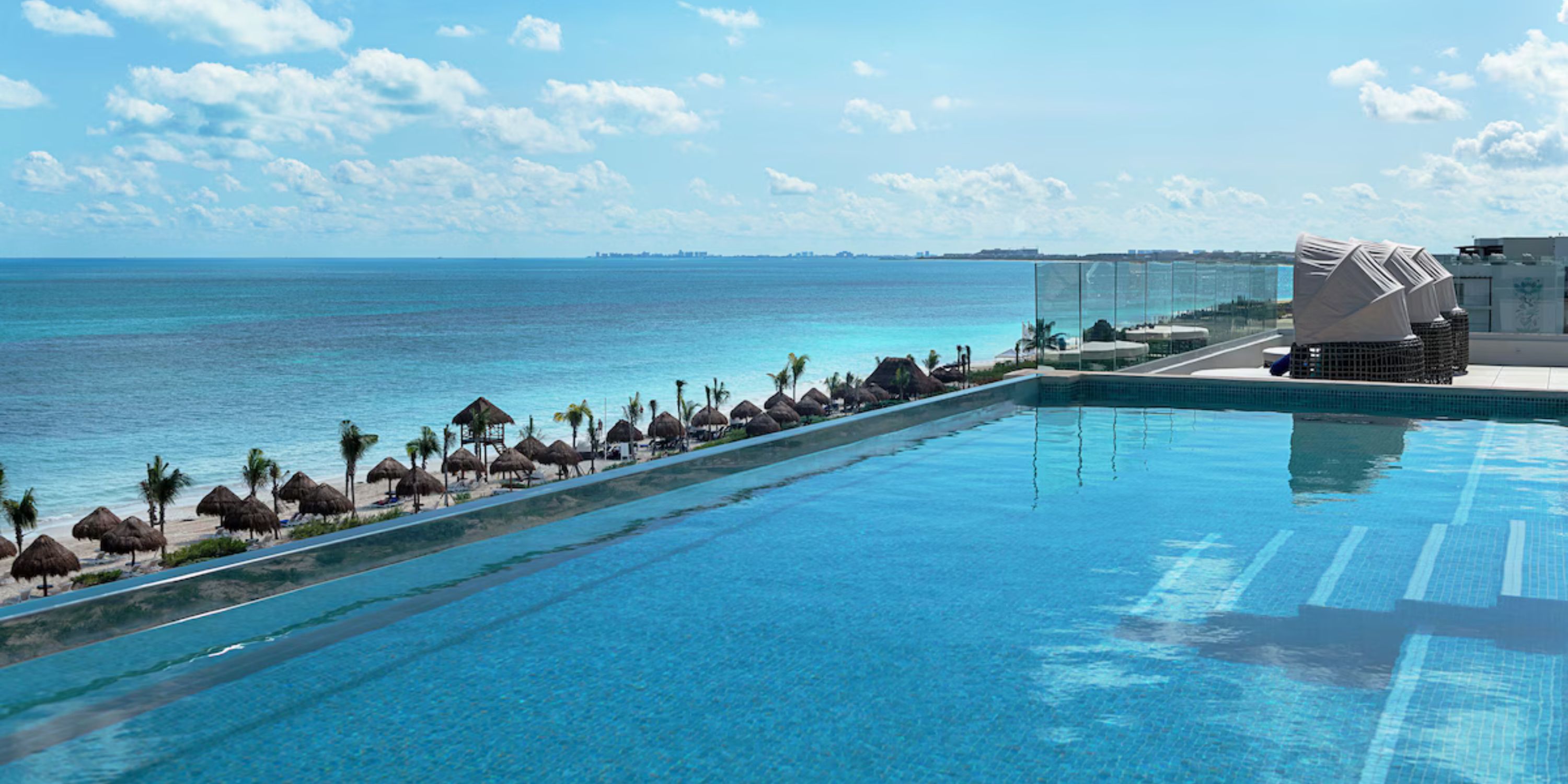 Infinity pool at Ocean Coral and Turquesa, ideal for a destination wedding with ocean views and palms.
