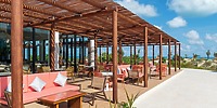 Patio at Ocean Coral and Turquesa with pergola, pink seats, ocean view&mdash;perfect for a destination wedding.