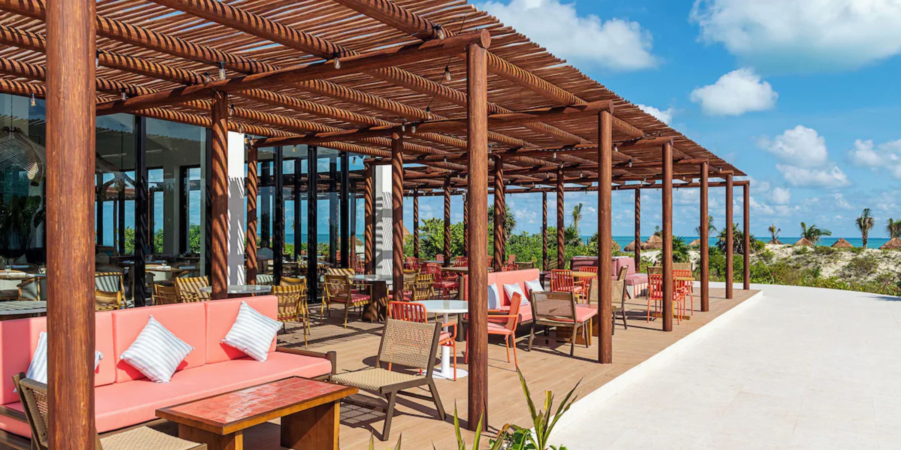 Patio at Ocean Coral and Turquesa with pergola, pink seats, ocean view&mdash;perfect for a destination wedding.