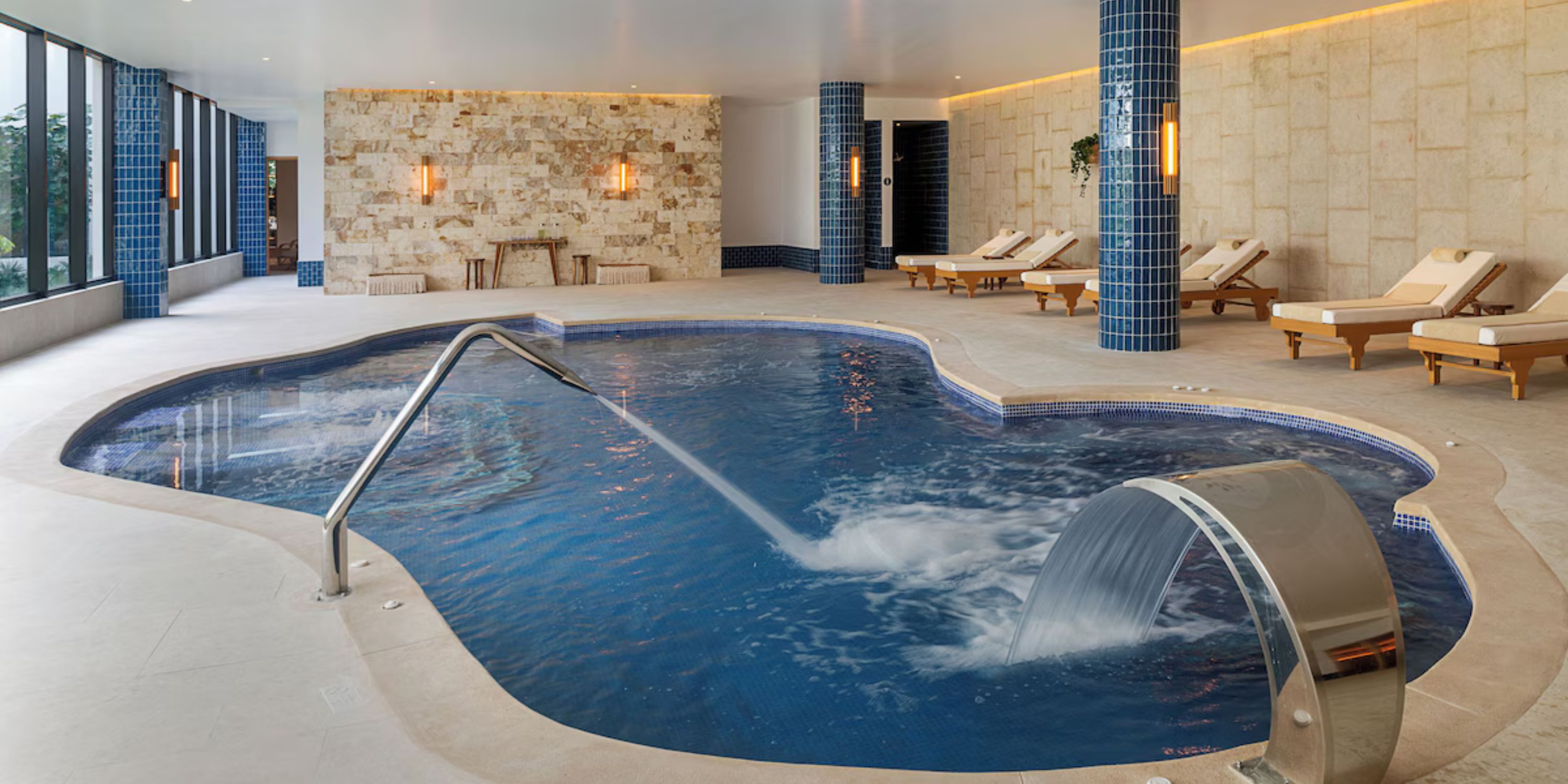 Indoor spa pool at Ocean Coral and Turquesa, ideal for destination wedding relaxation, with jets and lounge chairs.