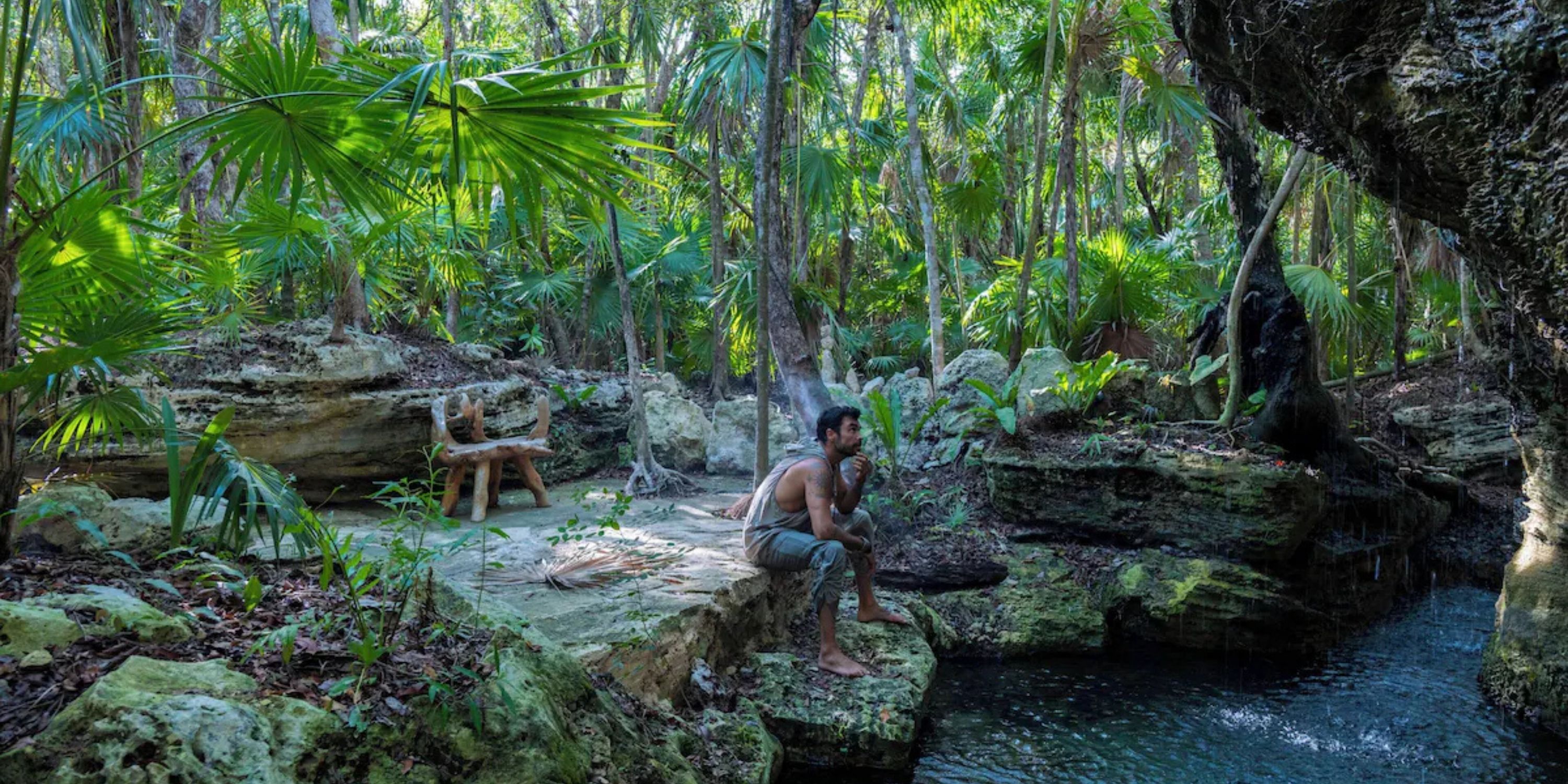 A man sits by a pool at Sandos Playacar, a popular destination wedding spot with jungle and rustic decor.