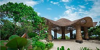 Sandos Playacar pavilion, ideal for a destination wedding, nestled in lush greenery under blue skies.