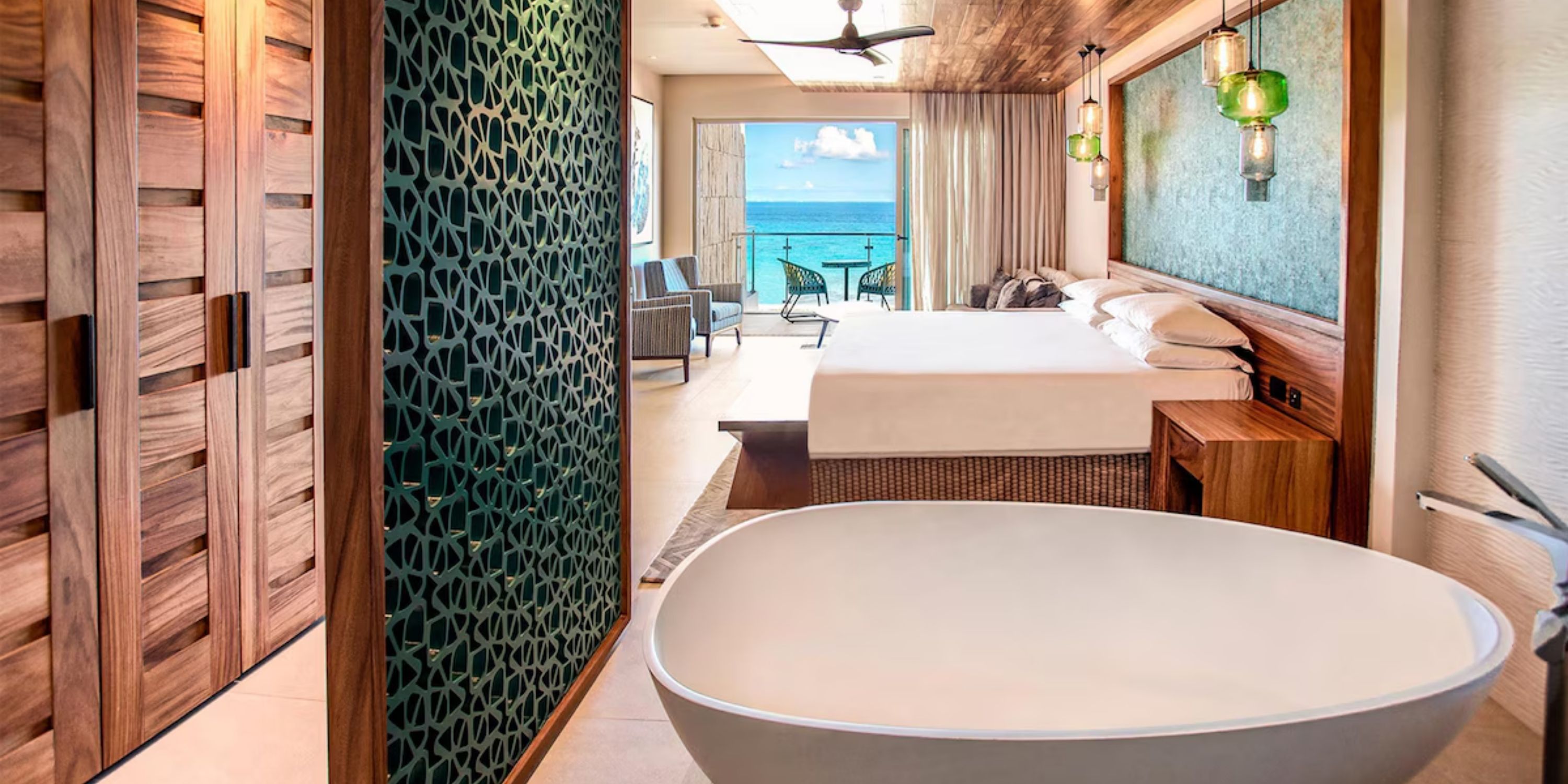 Elegant Sandos Playacar room with king bed, freestanding tub & ocean-view balcony for destination weddings.