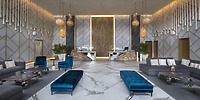 Sandos Playacar lobby: a chic destination wedding setting with marble floors, blue seats, and elegant lighting.