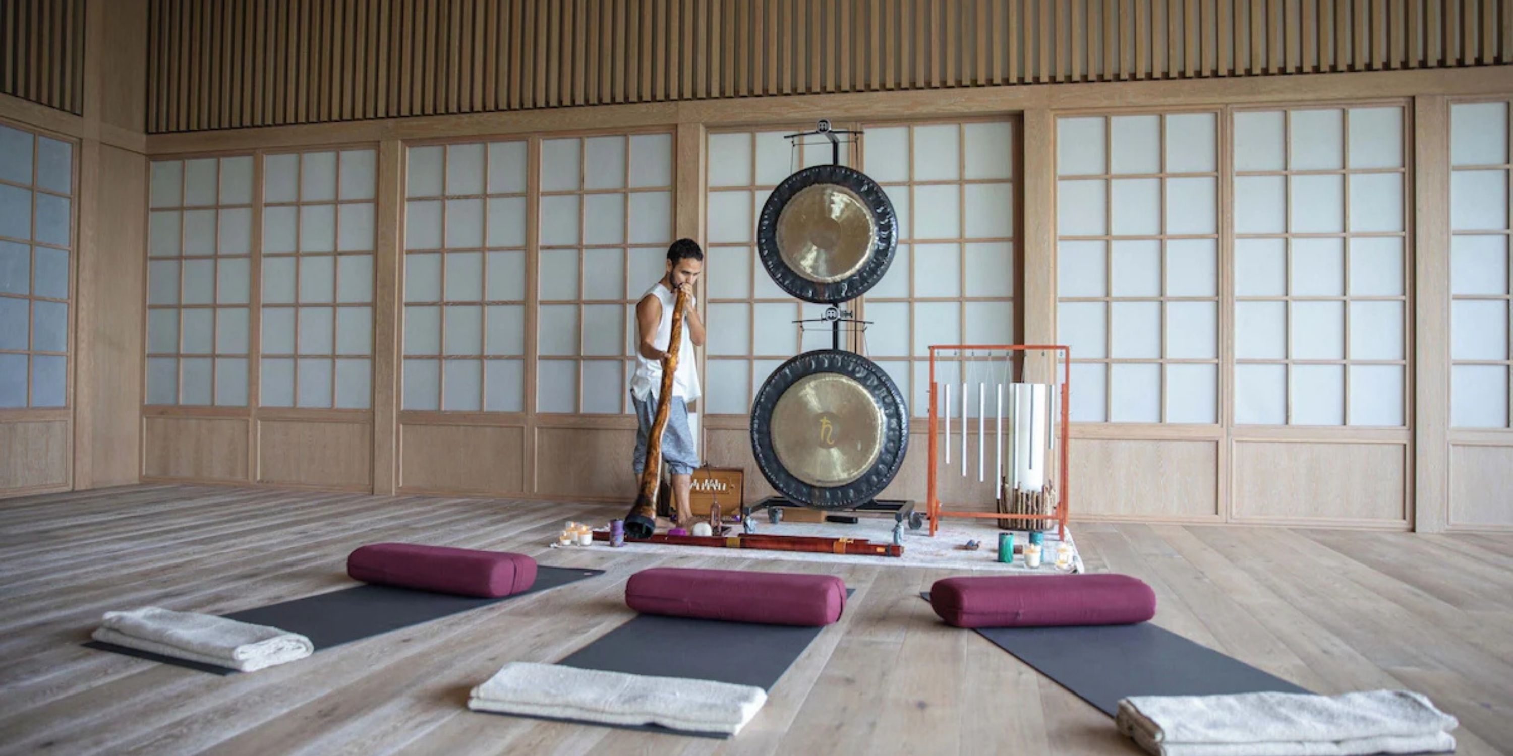At Sandos Playacar, a person prepares for sound therapy with gongs and yoga mats at a destination wedding.