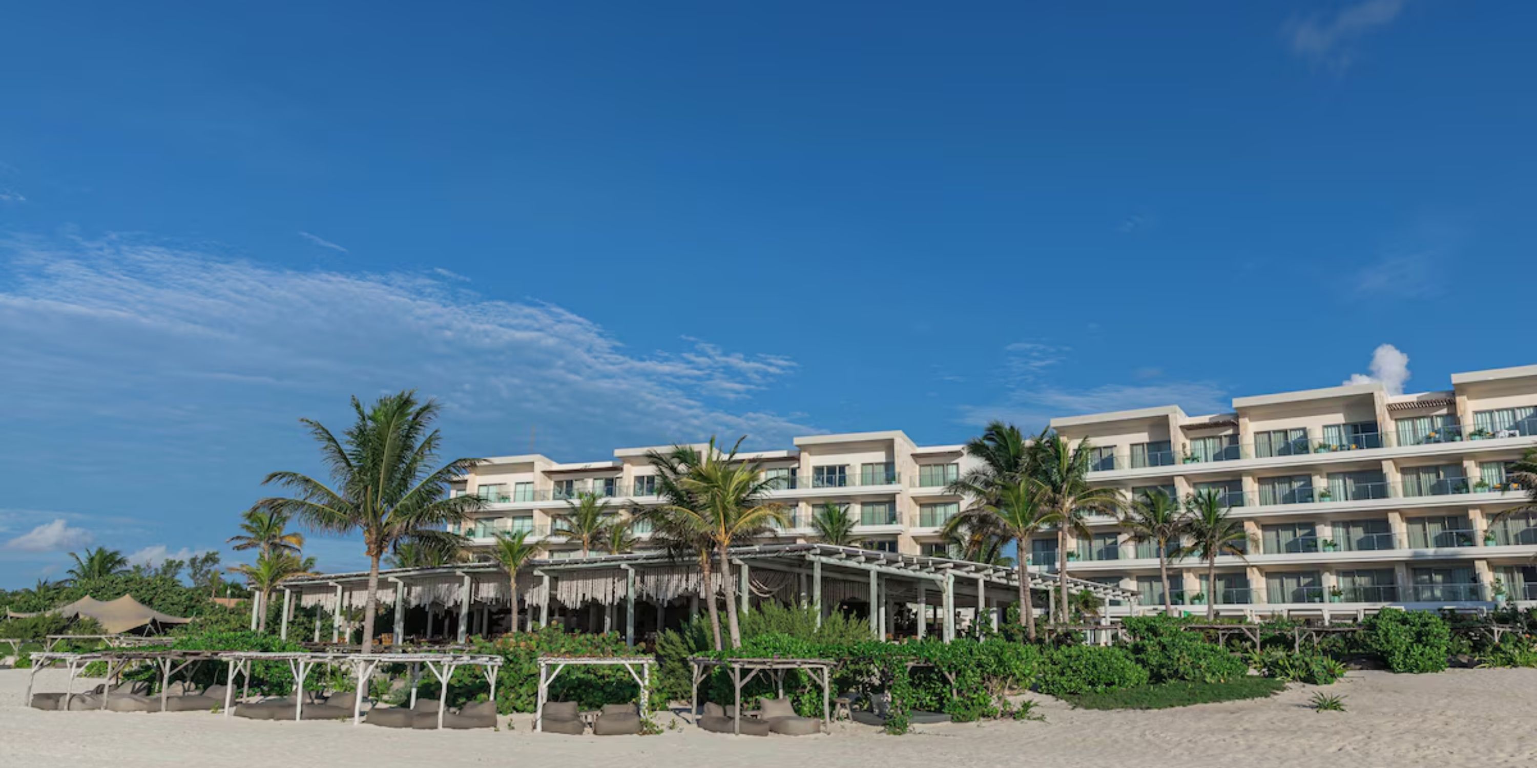 Sandos Playacar: A stunning beachfront resort with palm trees and cabanas, perfect for a destination wedding.