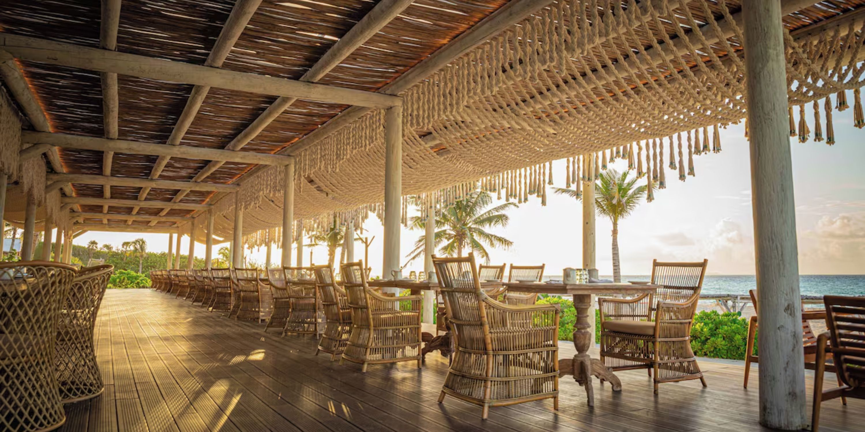 Open-air dining at Sandos Playacar with wicker chairs, perfect for a destination wedding by the ocean.