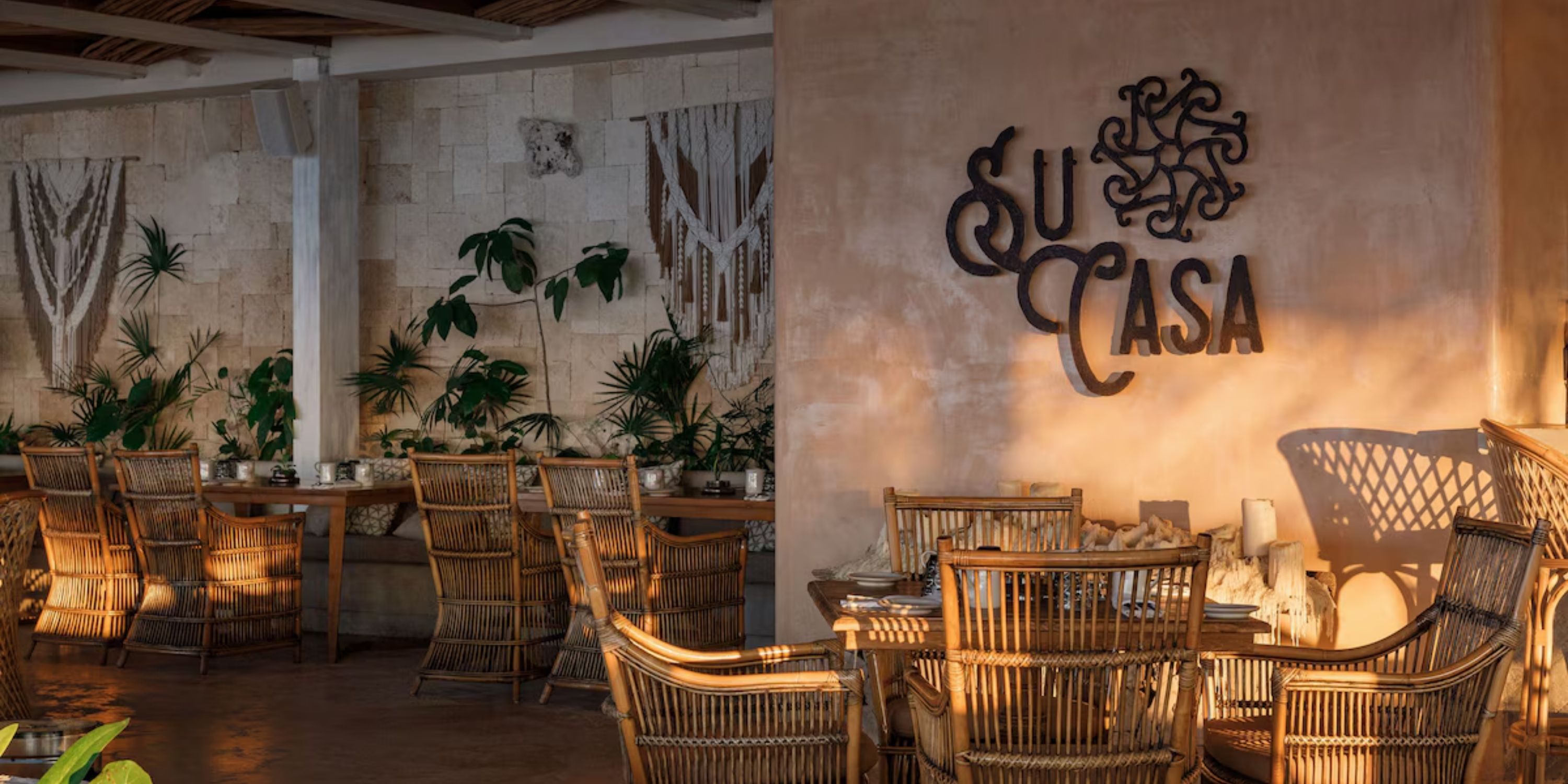 Outdoor seating at Sandos Playacar, ideal for a destination wedding, with wicker chairs and "Su Casa" sign.