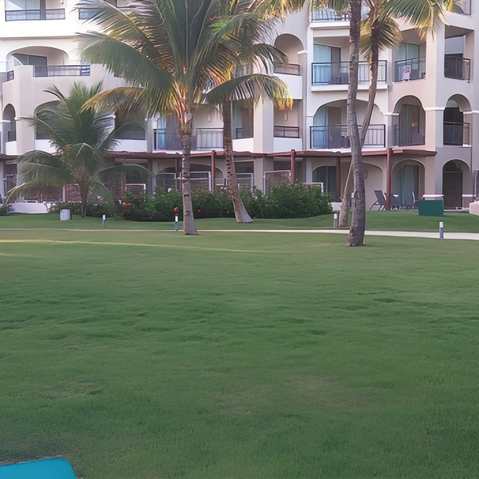 Palm trees on a green lawn create a perfect destination wedding backdrop in front of a hotel with balconies.