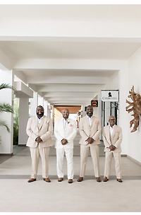 Four men in suits model Catherine and Carlos (Copy), side by side in a corridor at a destination wedding.