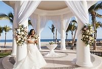 Tiffany and Anthony celebrate their destination wedding under a beach gazebo, bride in white bouquet.