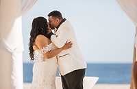 Tiffany and Anthony (Copy) share a kiss in formal attire at their beautiful destination wedding on the beach.