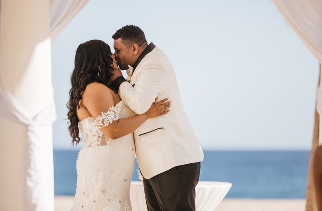 Tiffany and Anthony (Copy) share a kiss in formal attire at their beautiful destination wedding on the beach.