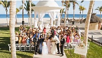 Tiffany and Anthony&rsquo;s destination wedding on the beach, guests cheering and celebrating around the couple.