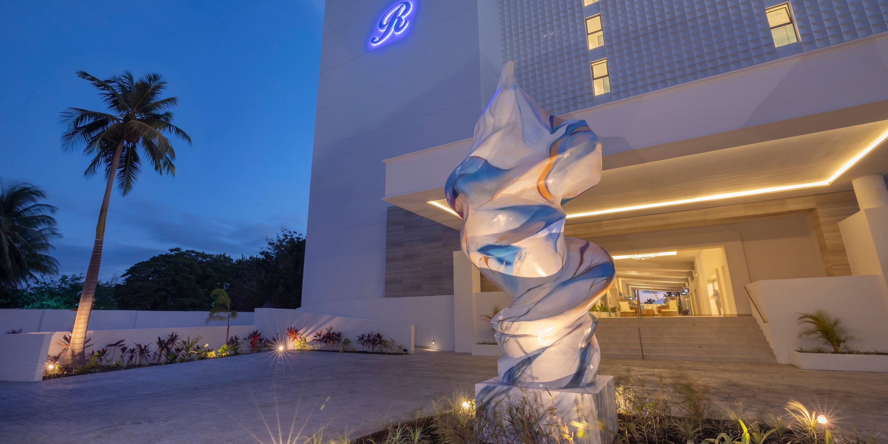 Royalton Vessence Barbados entrance at dusk, perfect for a destination wedding, sculpture and palms.