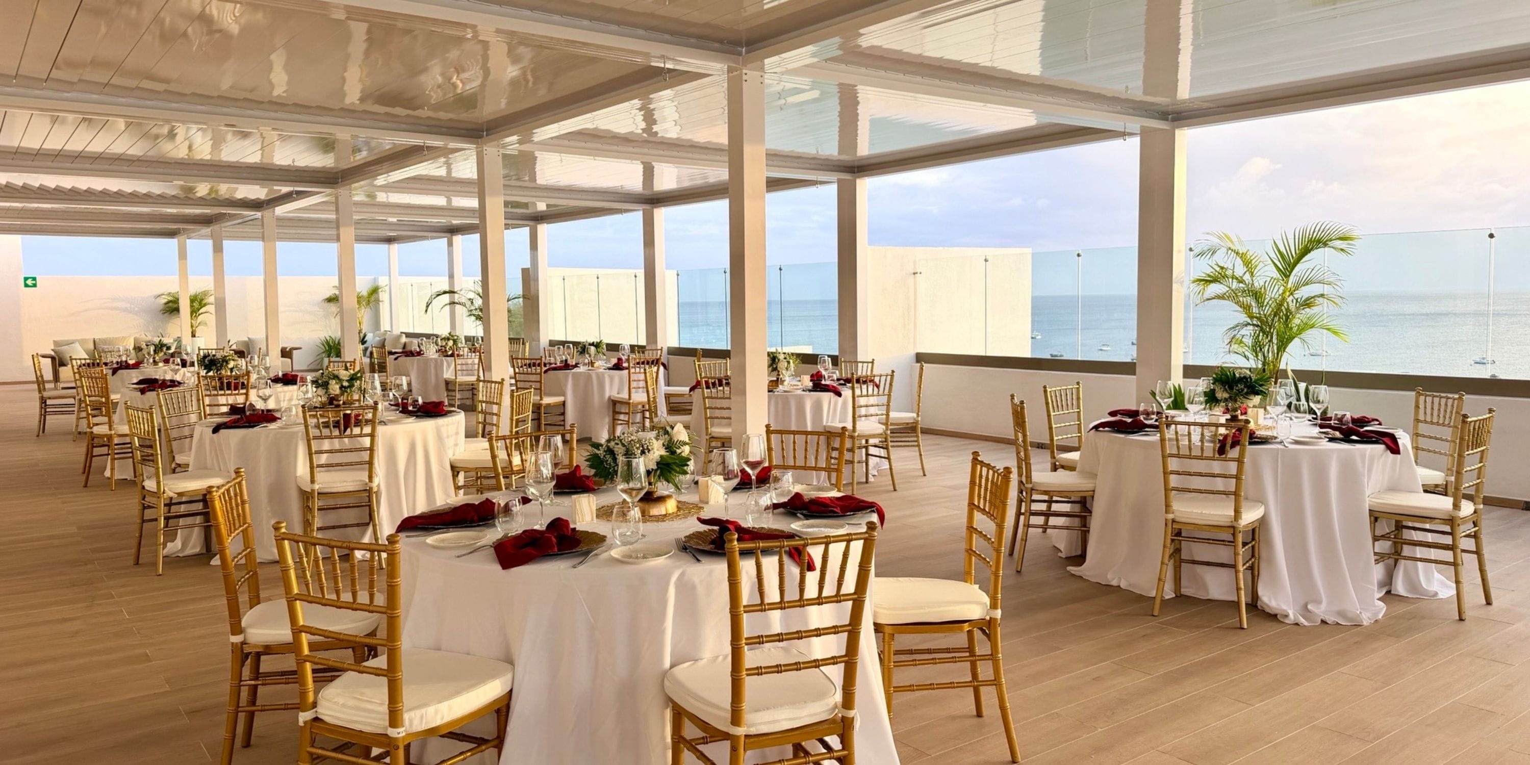 Royalton Vessence Barbados: elegant wedding space, round tables, gold chairs, ocean view.