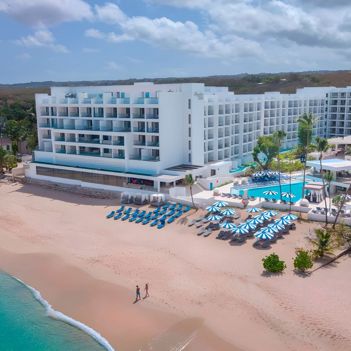 Royalton Vessence Barbados: a modern beachfront hotel ideal for destination weddings, with pools, loungers & umbrellas on the sand.
