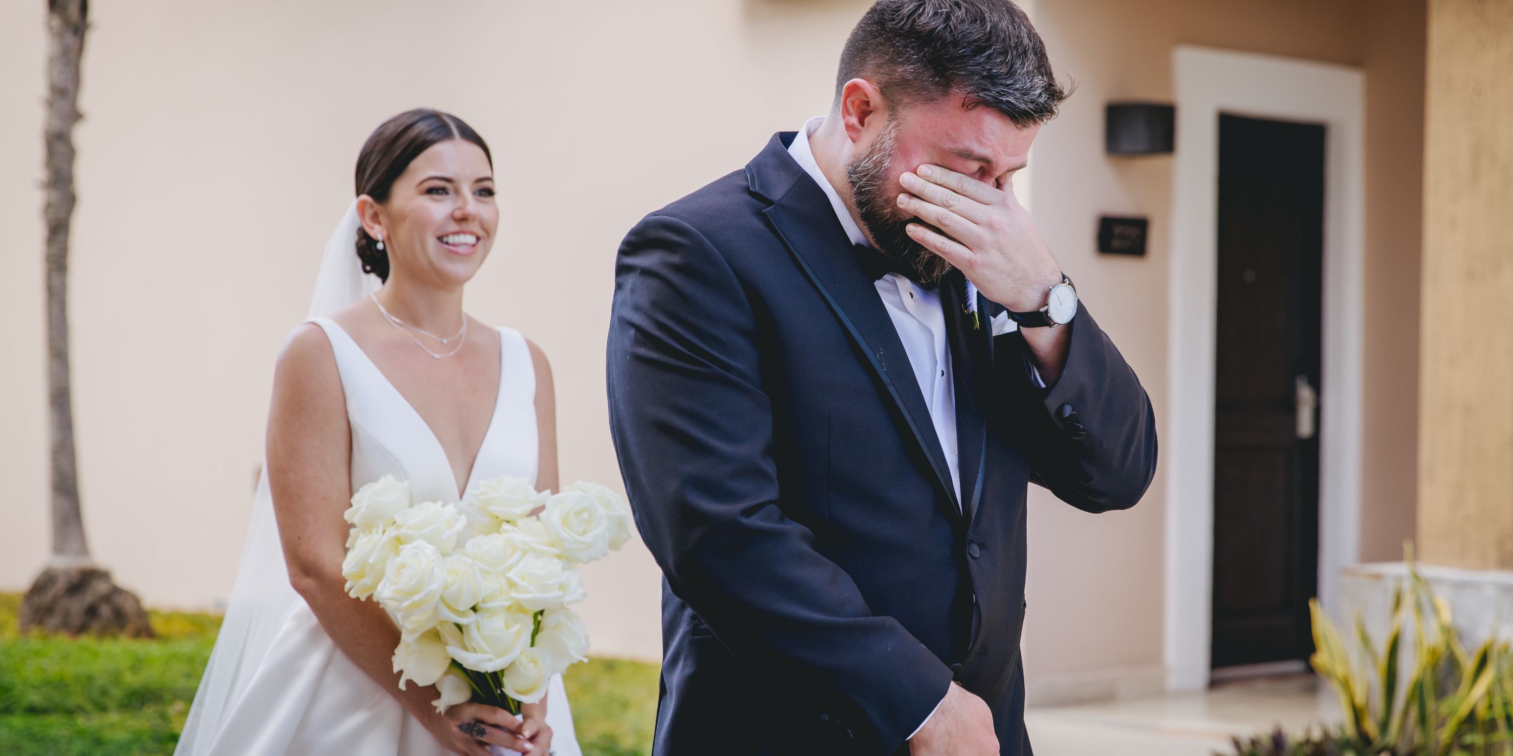 At their destination wedding first look, Kathryn smiles behind Mike as he wipes tears from his eyes.