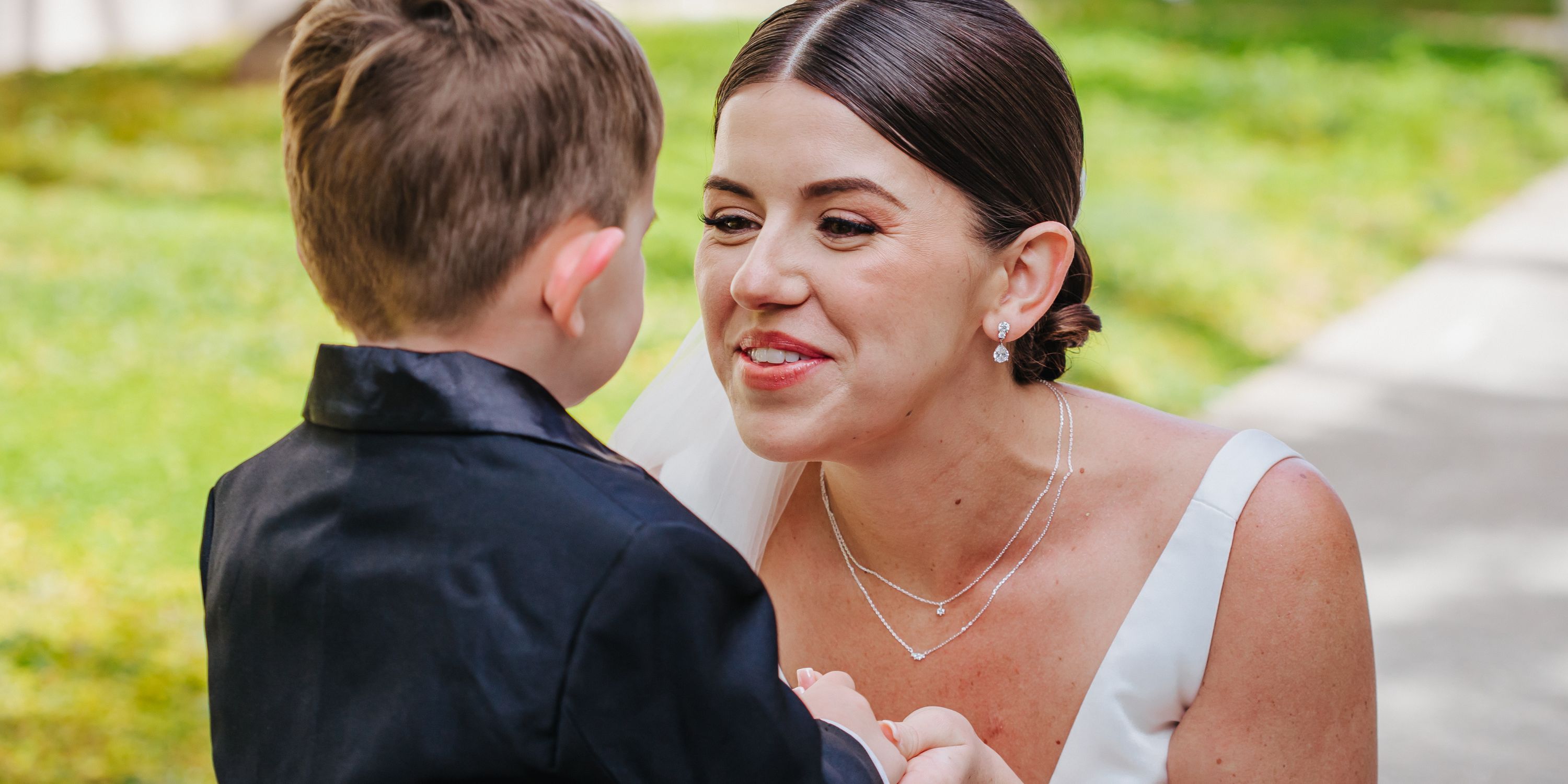 Kathryn and Mike smiling at their destination wedding outdoors, she in a white dress, he in black suit.