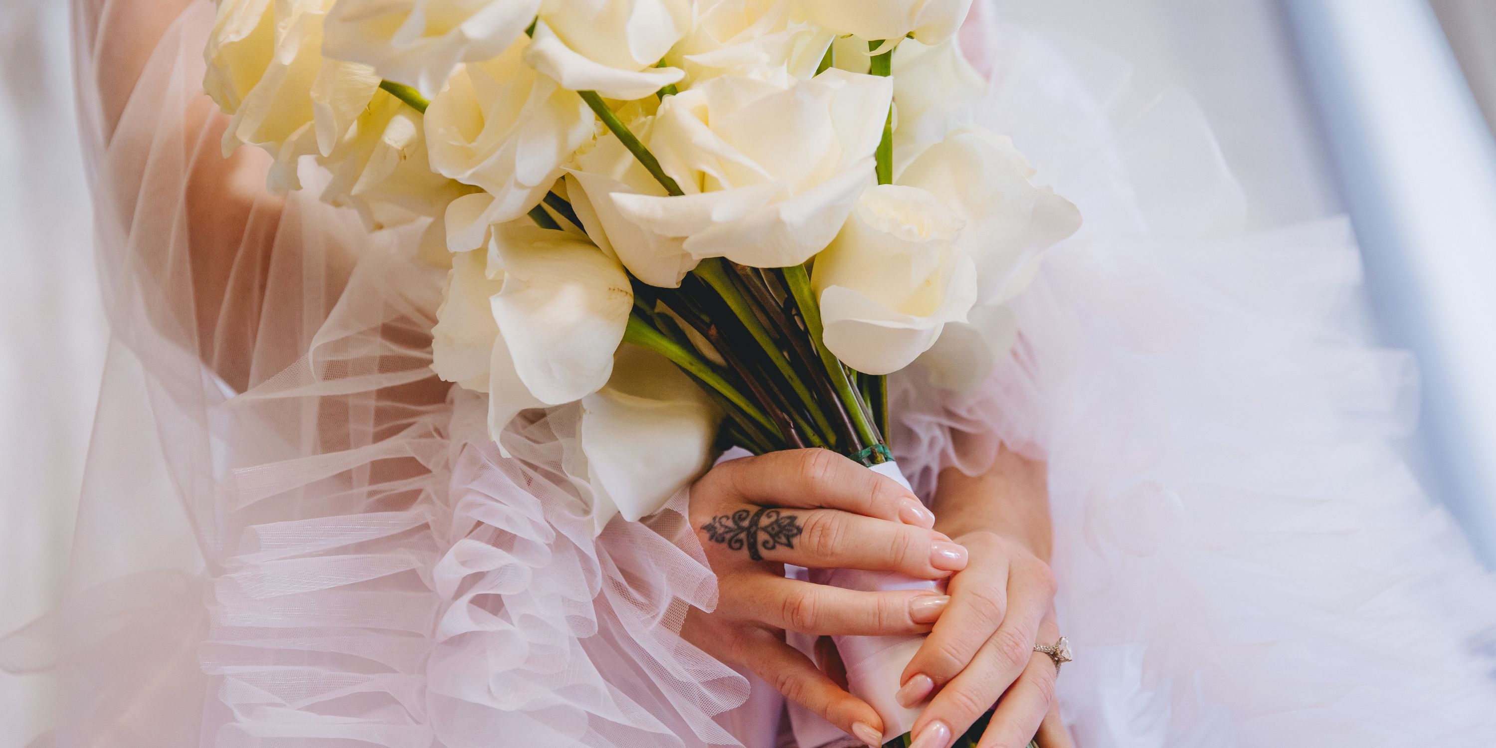 Person at a destination wedding holding the Kathryn and Mike bouquet, dressed in a ruffled pale pink dress.