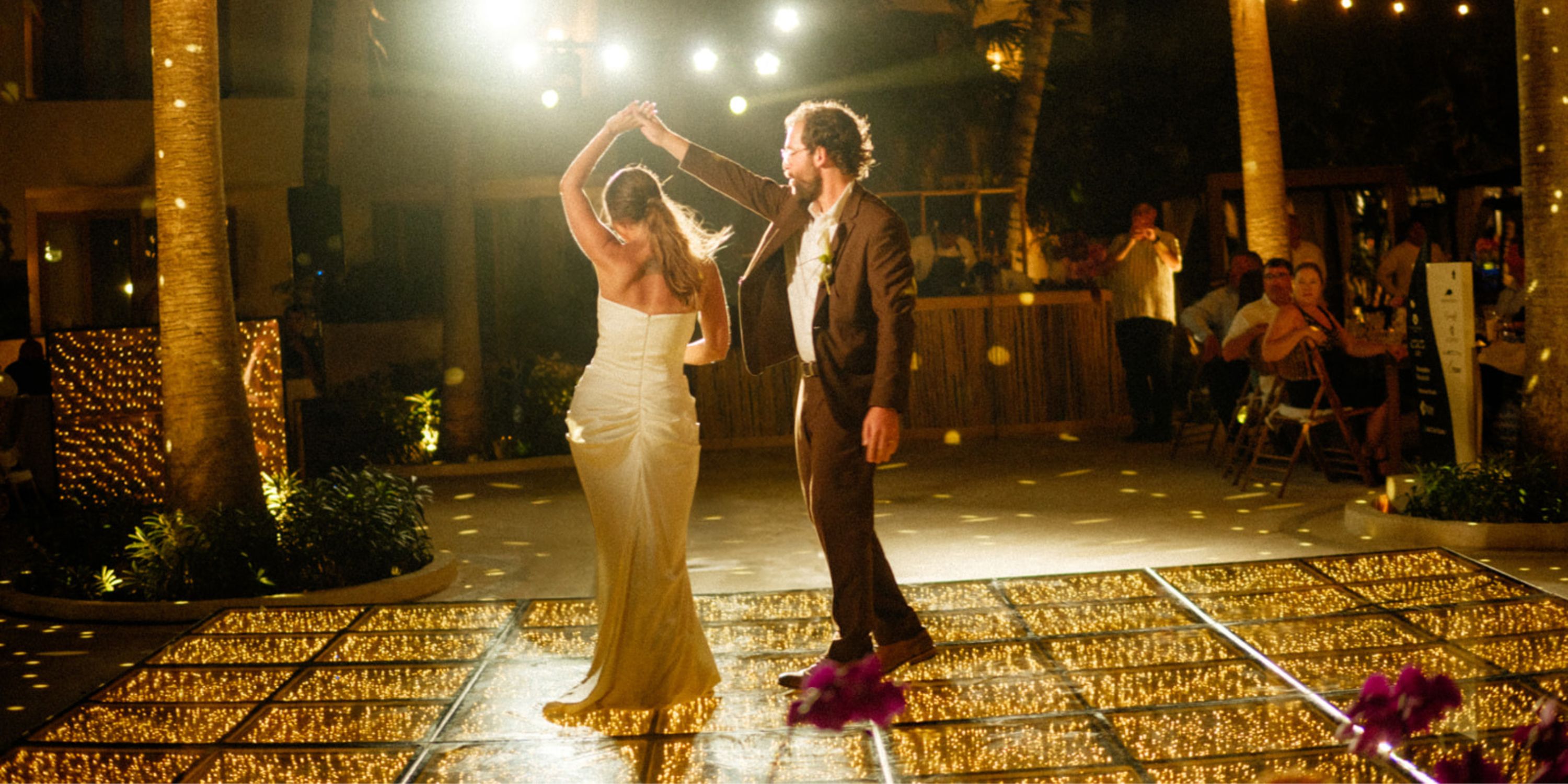 Ethan and Erica share a dance on a glowing outdoor floor at their destination wedding at night.
