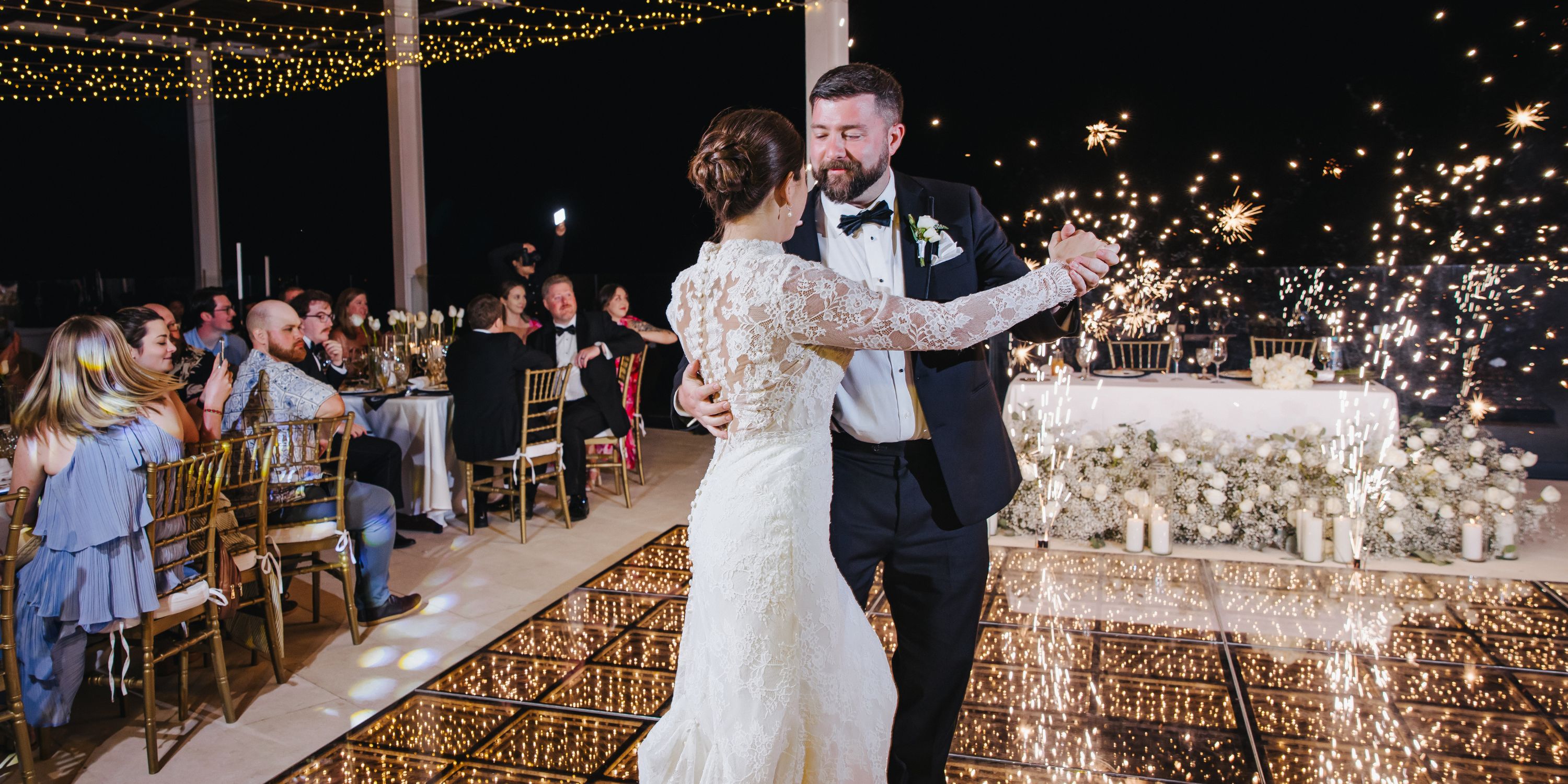 Kathryn and Mike have their first dance at their wedding, with sparklers lighting up the background.