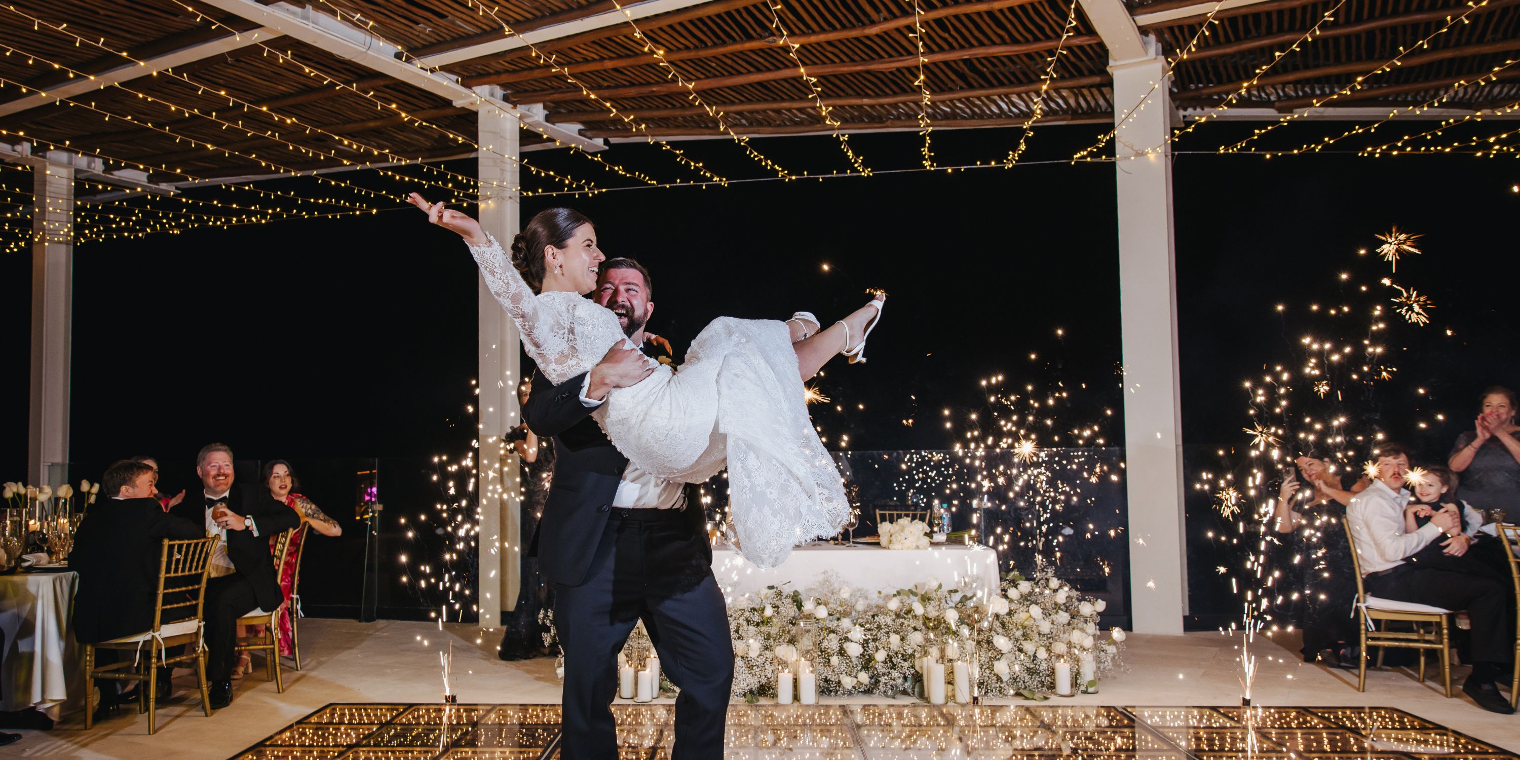 Kathryn and Mike celebrate at their destination wedding, dancing amid guests and twinkling lights.
