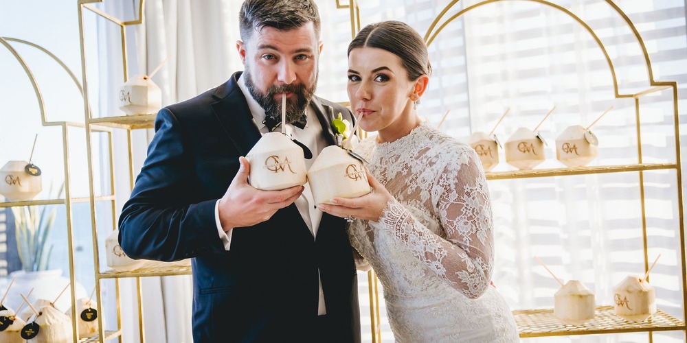 Kathryn and Mike enjoy personalized coconuts at their destination wedding in festive attire and venue.