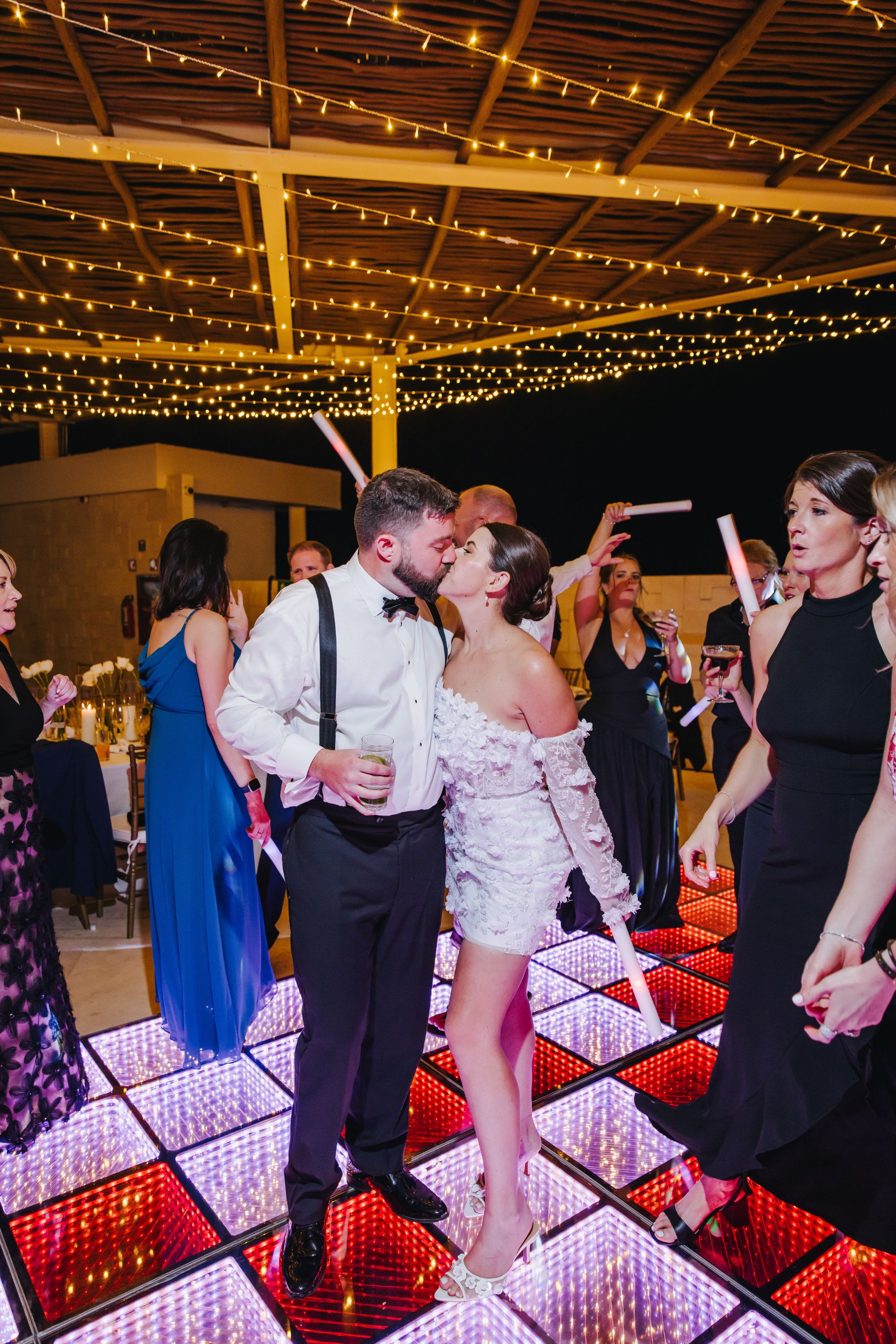 Kathryn and Mike share a kiss on the glowing dance floor during their nighttime destination wedding.