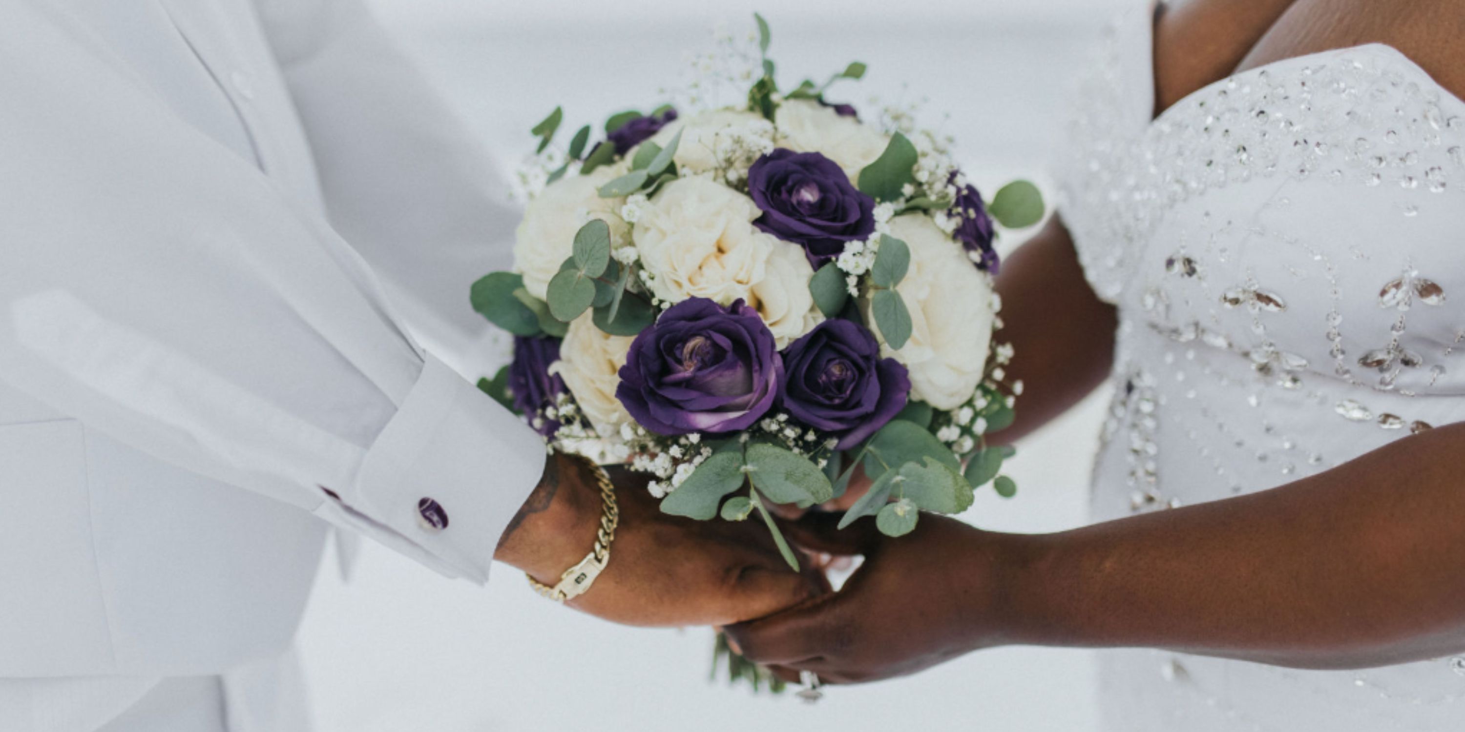 Ethan and Erica (Copy) hold a bouquet of purple and white flowers at their destination wedding.